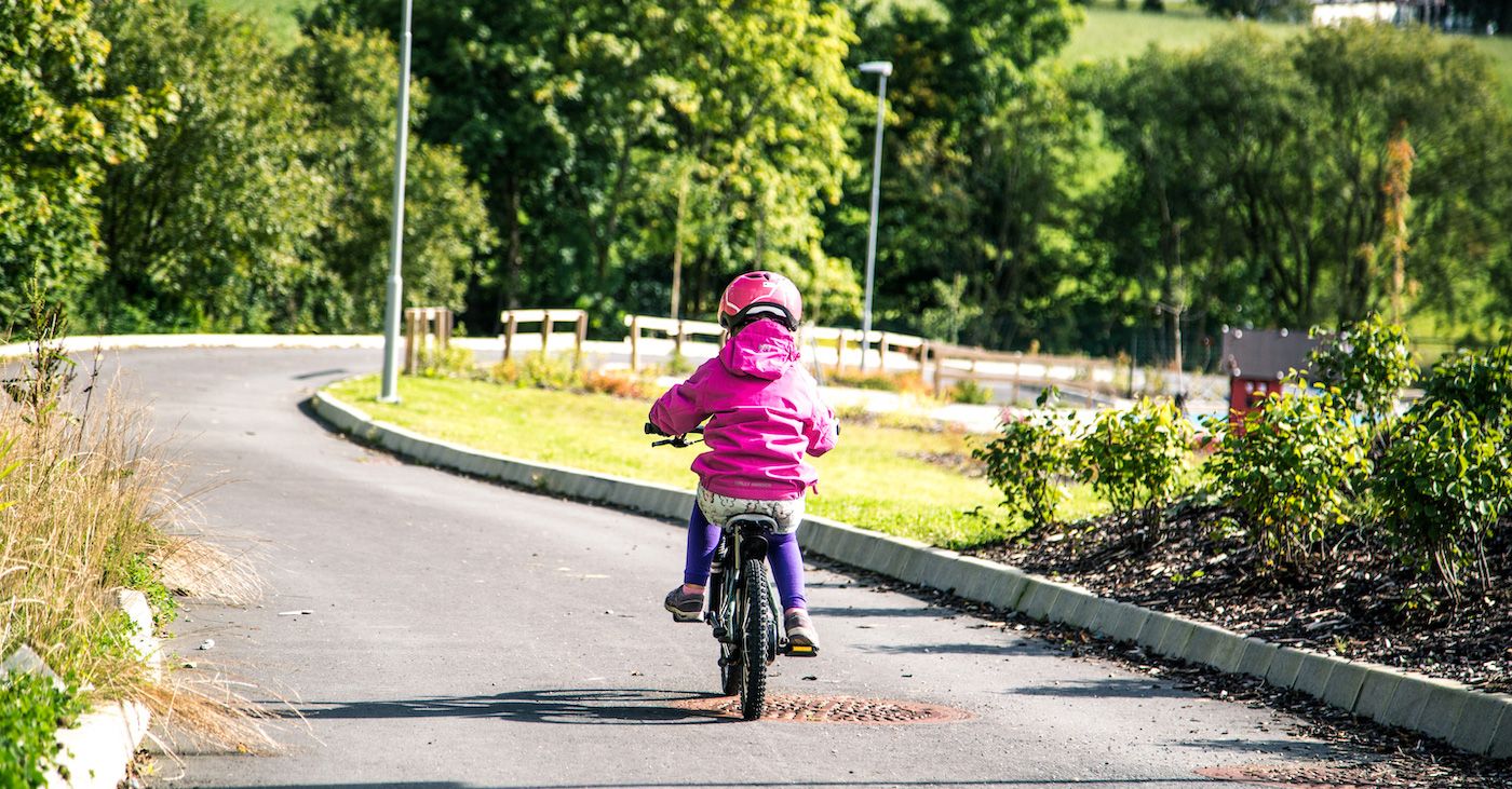 Jente sykler på sykkelsti