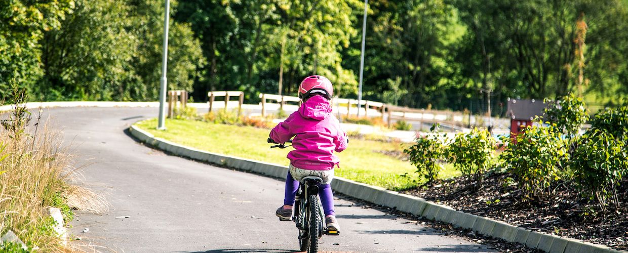 Jente sykler på sykkelsti