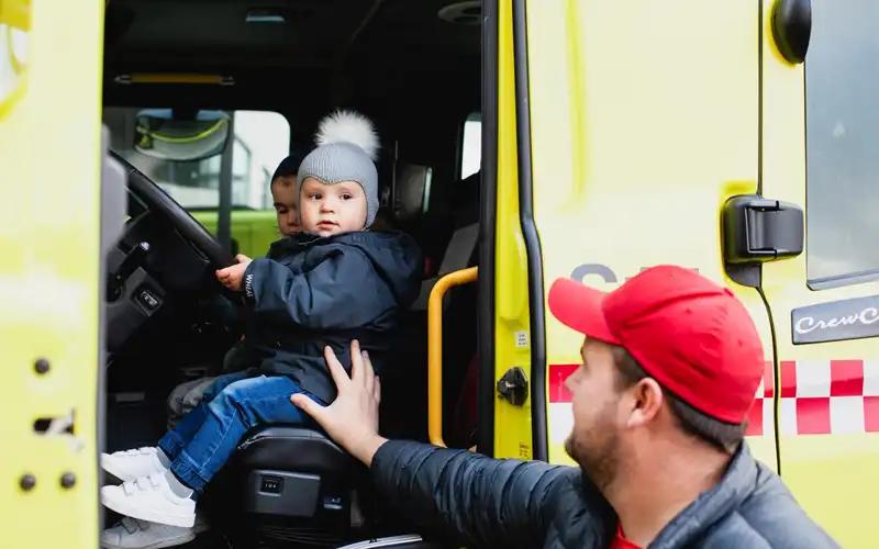 liten gutt sitter i brannbil