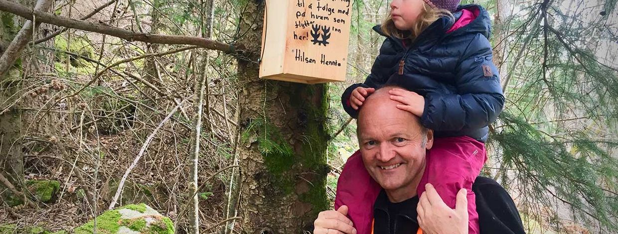 far og datter ved siden av en fuglekasse