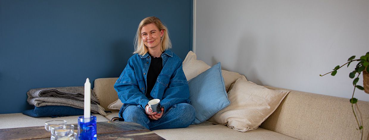 jente sitter i en sofa i bate bolig