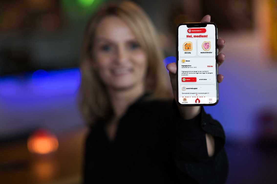 Dame holder mobil med Bate-appen på