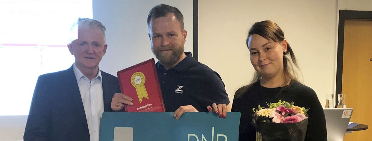 Tre personer med en gavesjekk fra dnb