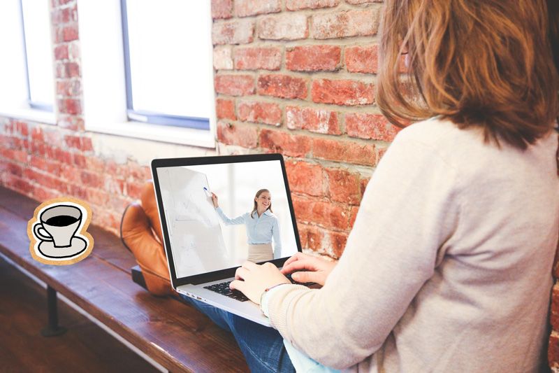 Dame sitter med pc i fanget på benk