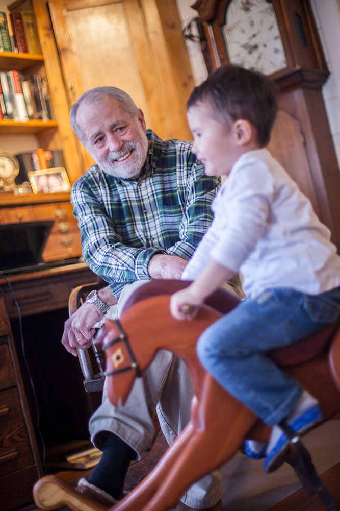 Bestefar ser på barnebarn som gynger på gyngehest
