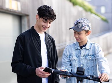 en ungdom og en gutt som ser på en mobiltelefon