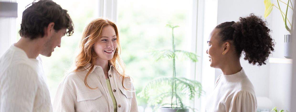 tre mennesker snakker på kjøkkenet