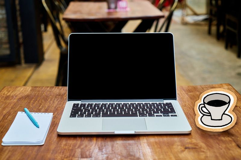 bord med mabook og kaffekopp i papp