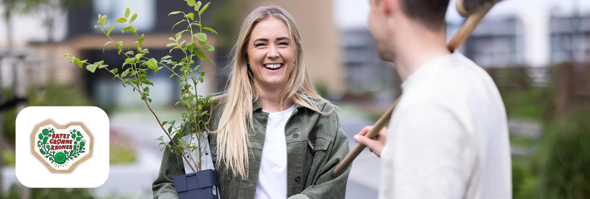 Kvinne holder grønn plante i en potte