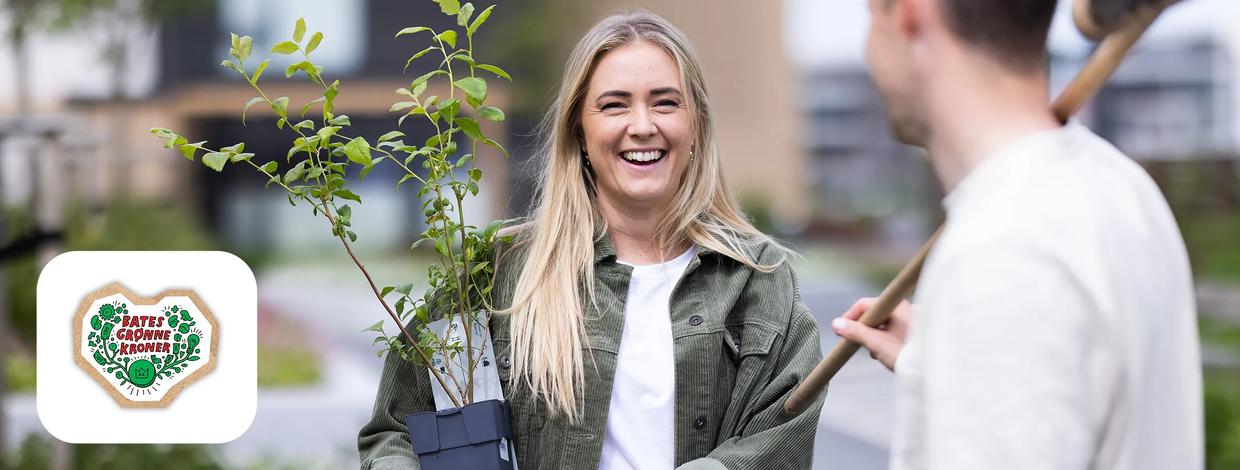 Kvinne holder grønn plante i en potte