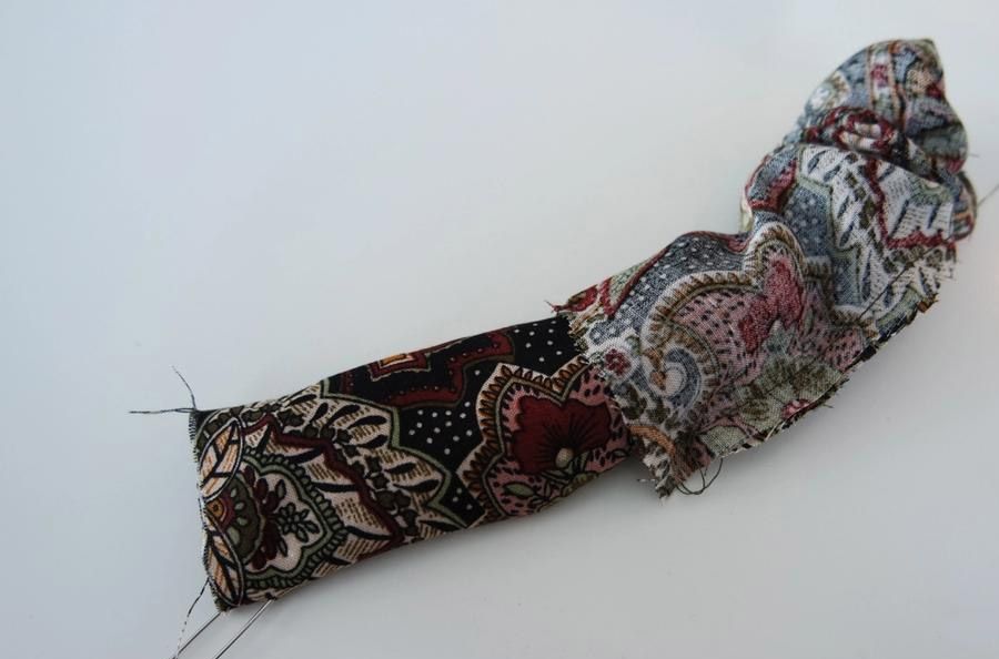 Stoffbit som blir vrengt ved hjelp av sikkerhetsnål