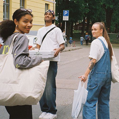 unge mennesker bærer på pizza og handleposer