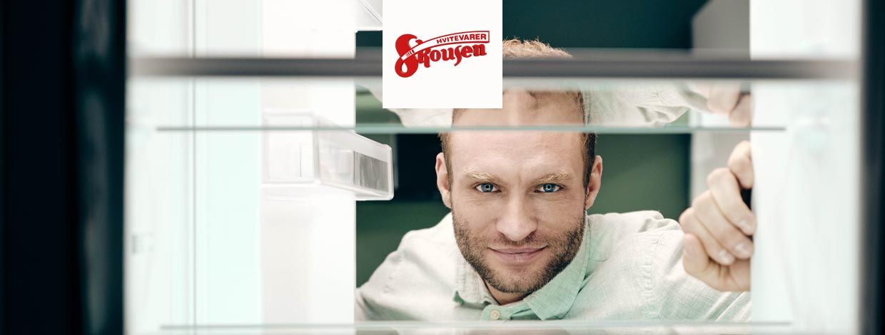 Mann kikker inn i en vaskemaskin.