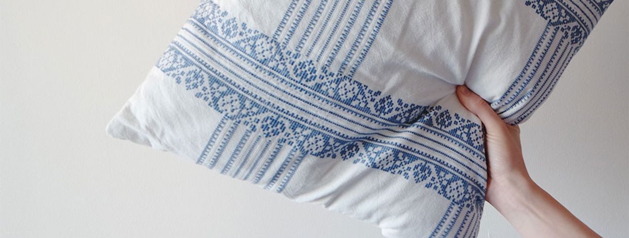 hånd holder pute med hjemmesydd trekk