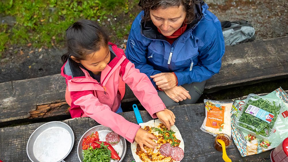 dame og jente tilbereder mat ute