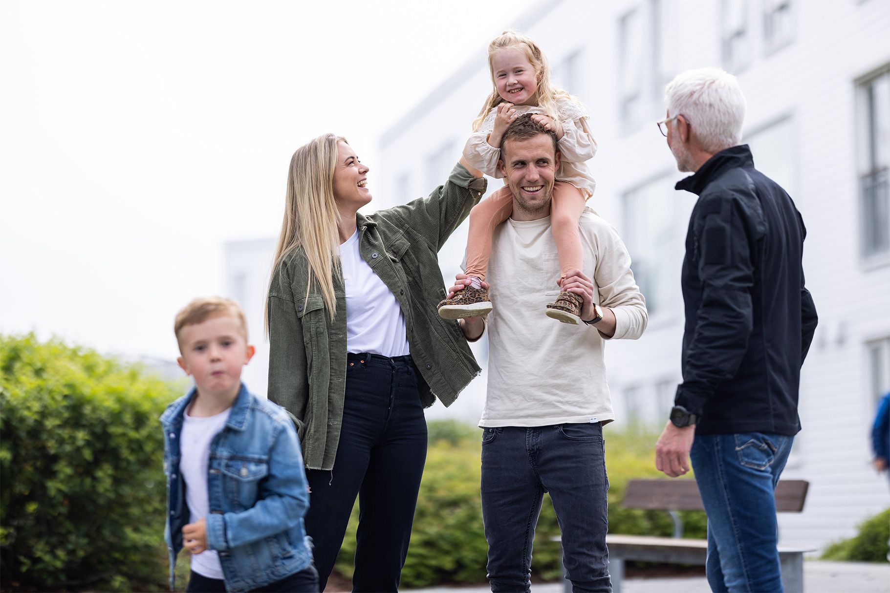 voksne og barn som prater og leker ute