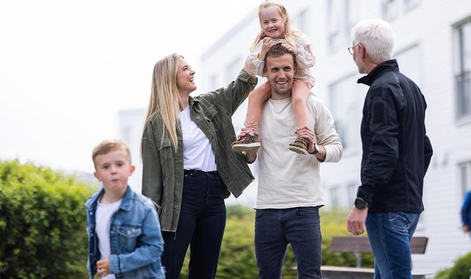 voksne og barn som prater og leker ute
