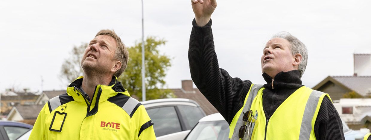 To menn vurderer bygningsmassen til et borettslag