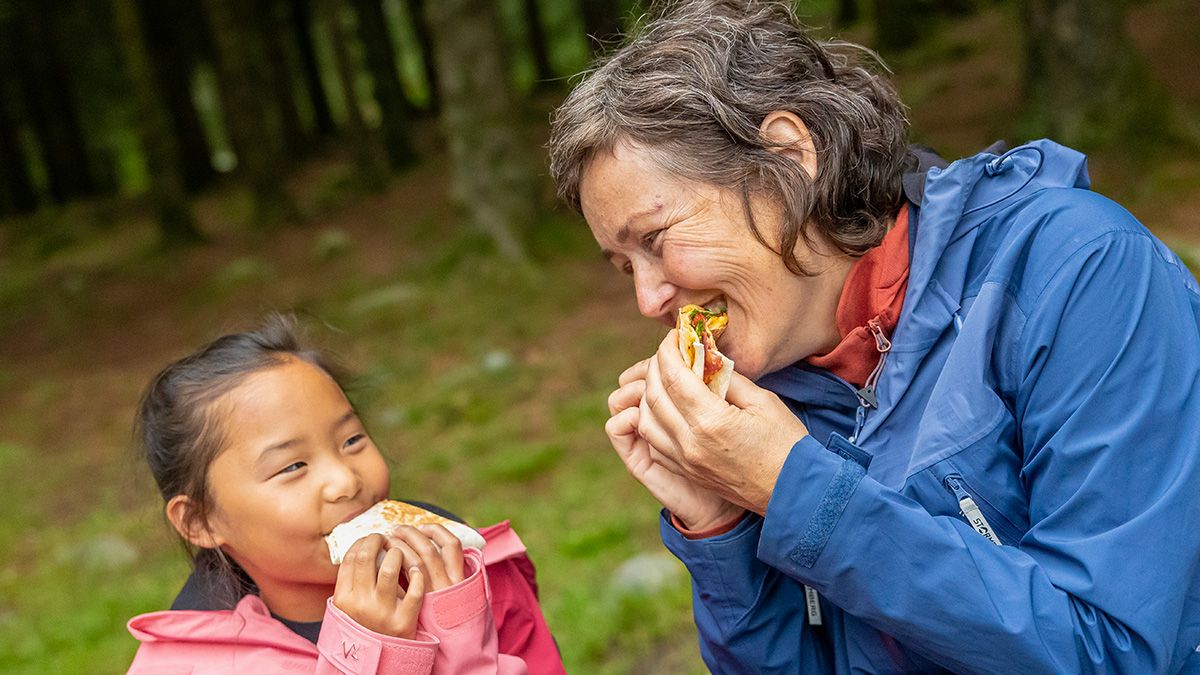 dame og jente spiser ute i naturen