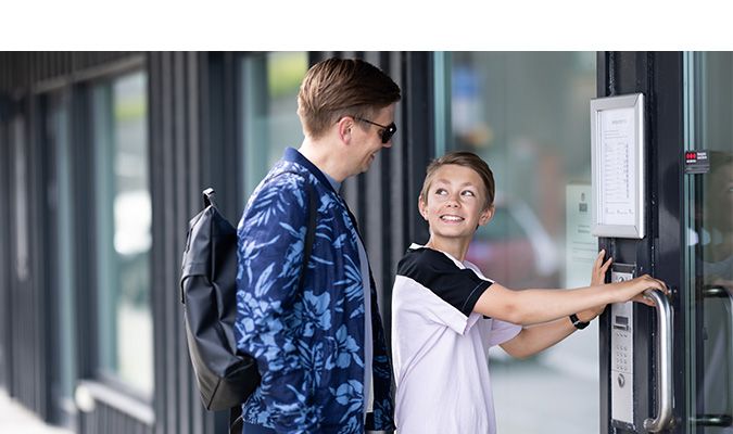 mann og gutt smiler og åpner dør