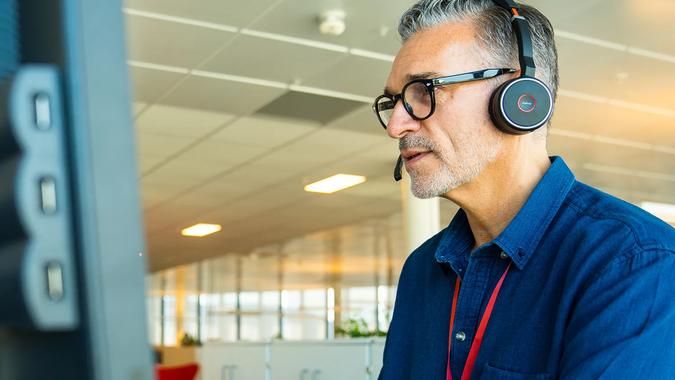 Bate-ansatt med hodetelefoner arbeider på en pc