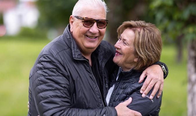 eldre par som holder rundt hverandre og ler
