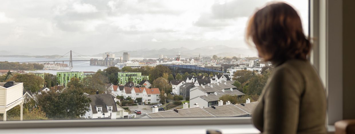 dame ser ut vinduet med utsikt over stavanger