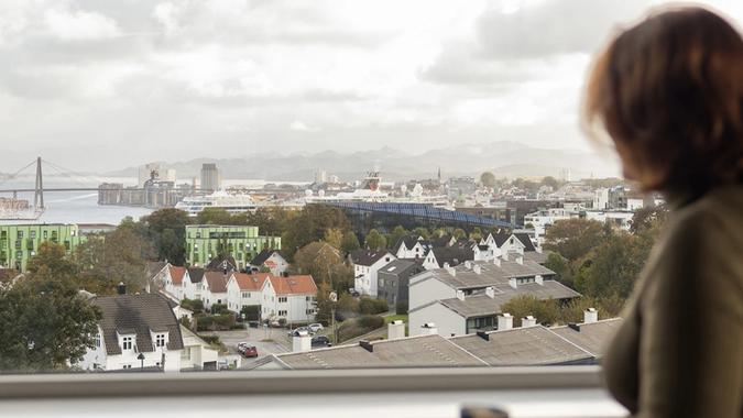 dame ser ut vinduet med utsikt over stavanger