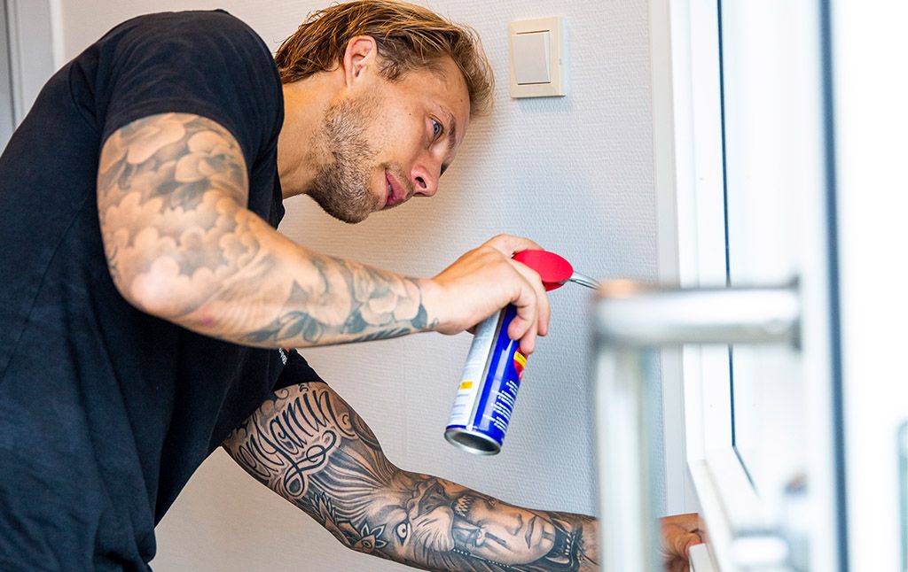 Vaktmester smører en dør