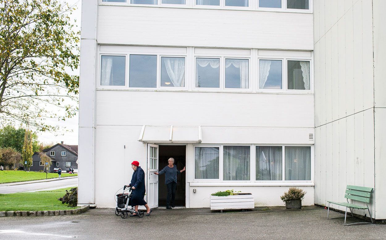 Dame med rullator utenfor bibliotek