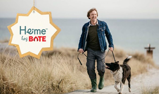 Mann går tur med hund på strand