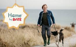 Mann går tur med hund på strand