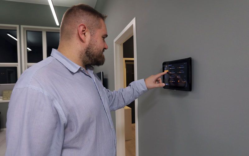 Bilde av Atle soma som kontrollerer lys og varme på nettbrett