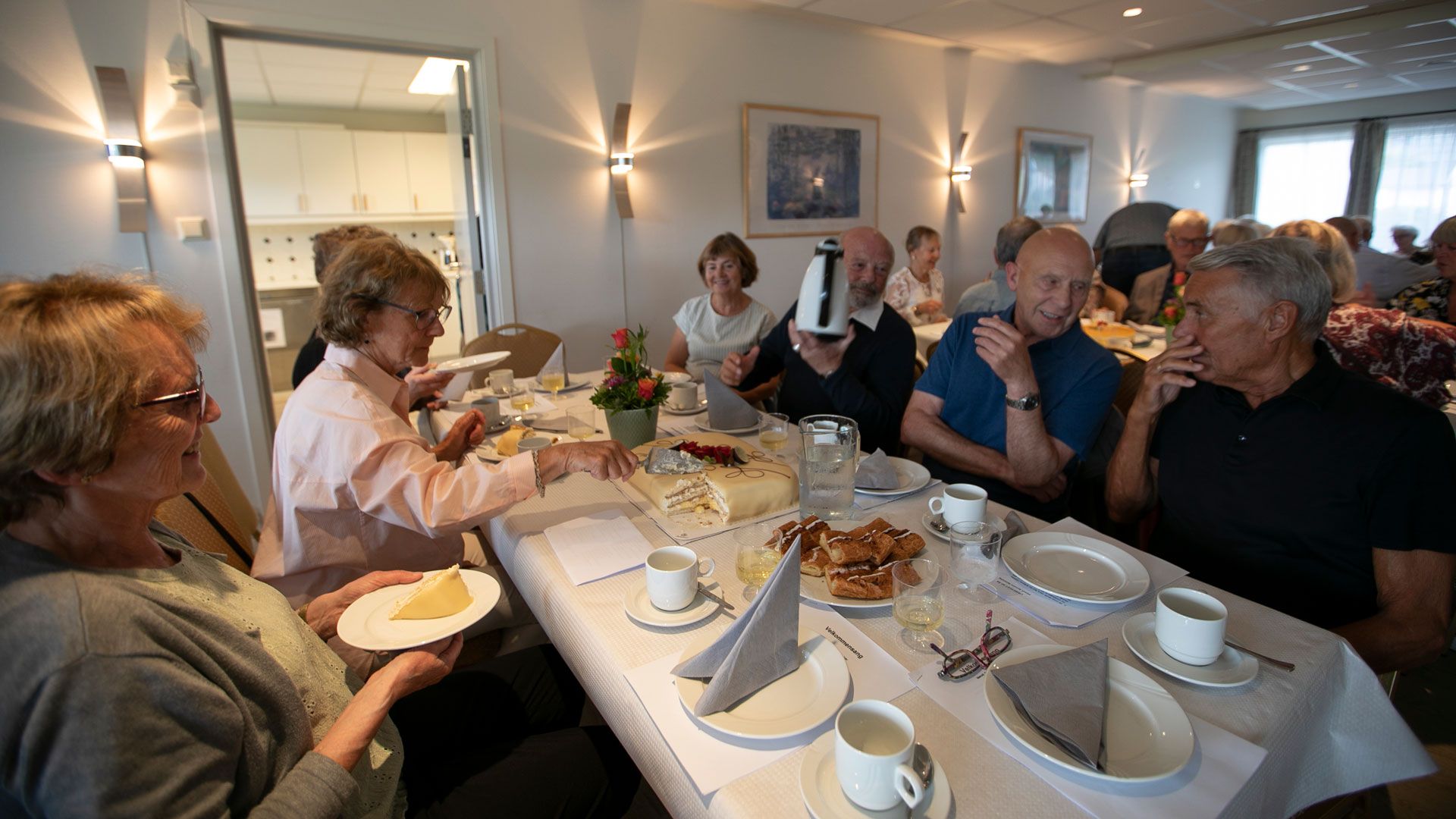Mennesker rundt kakebord