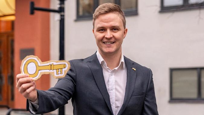 bankmann med en nøkkel i papp i hånden