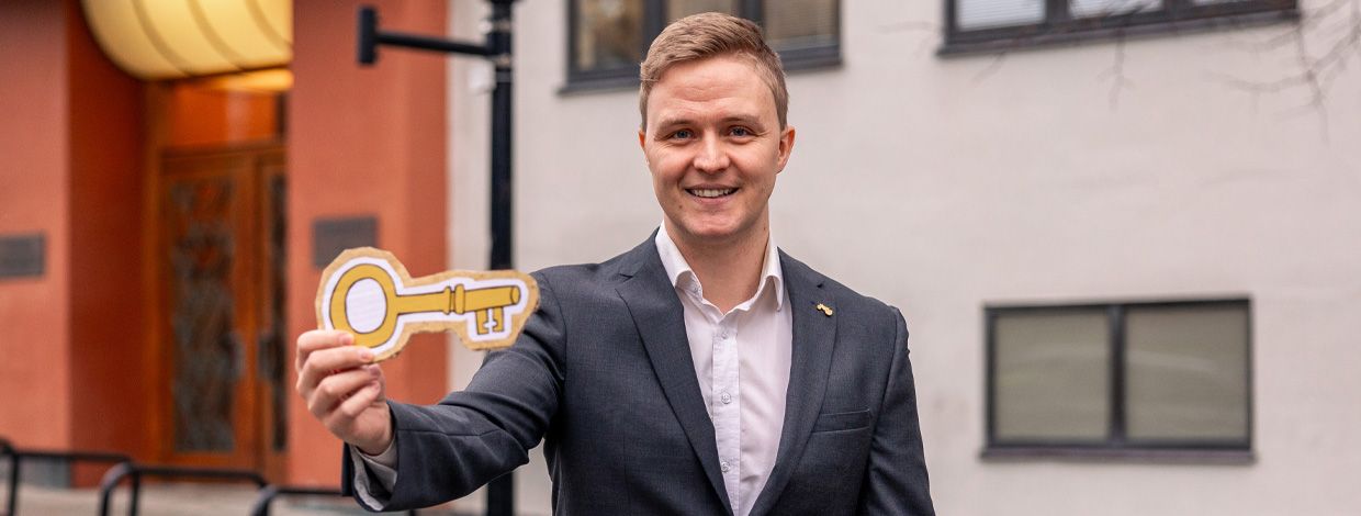 bankmann med en nøkkel i papp i hånden