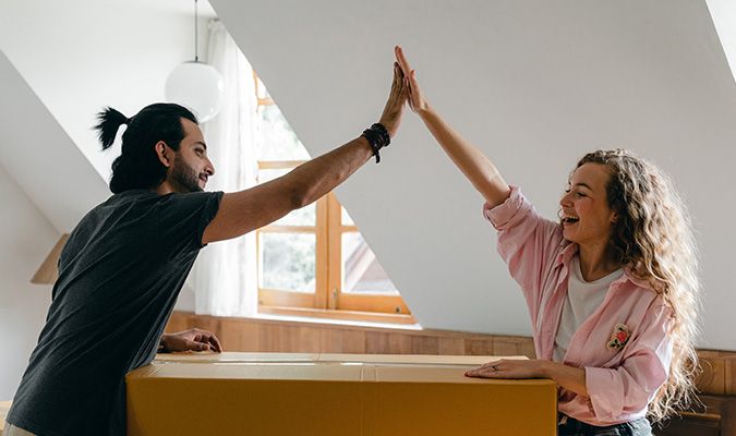 mann og dame high five over flytteeske