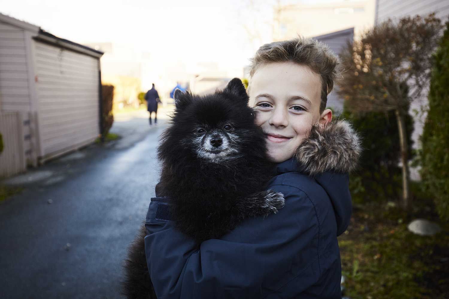 gutt holder en svart hund