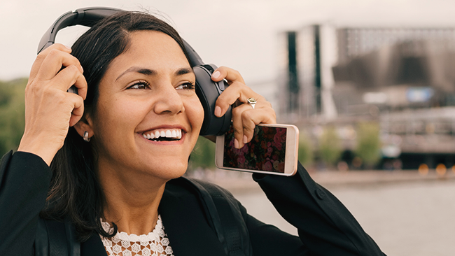 Nextory dame med mobil og headset