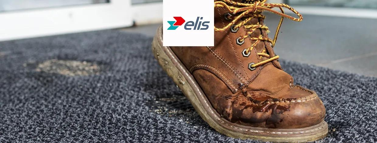 Sko som trør på en skitten matte