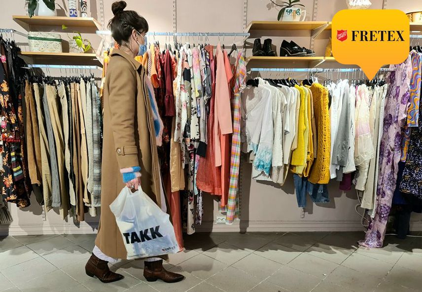 Dame i kåpe handler hos en fretex butikk