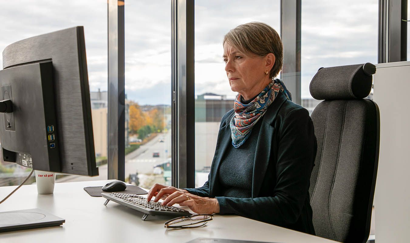 Kunderådgiver jobber på datamaskin på kontor