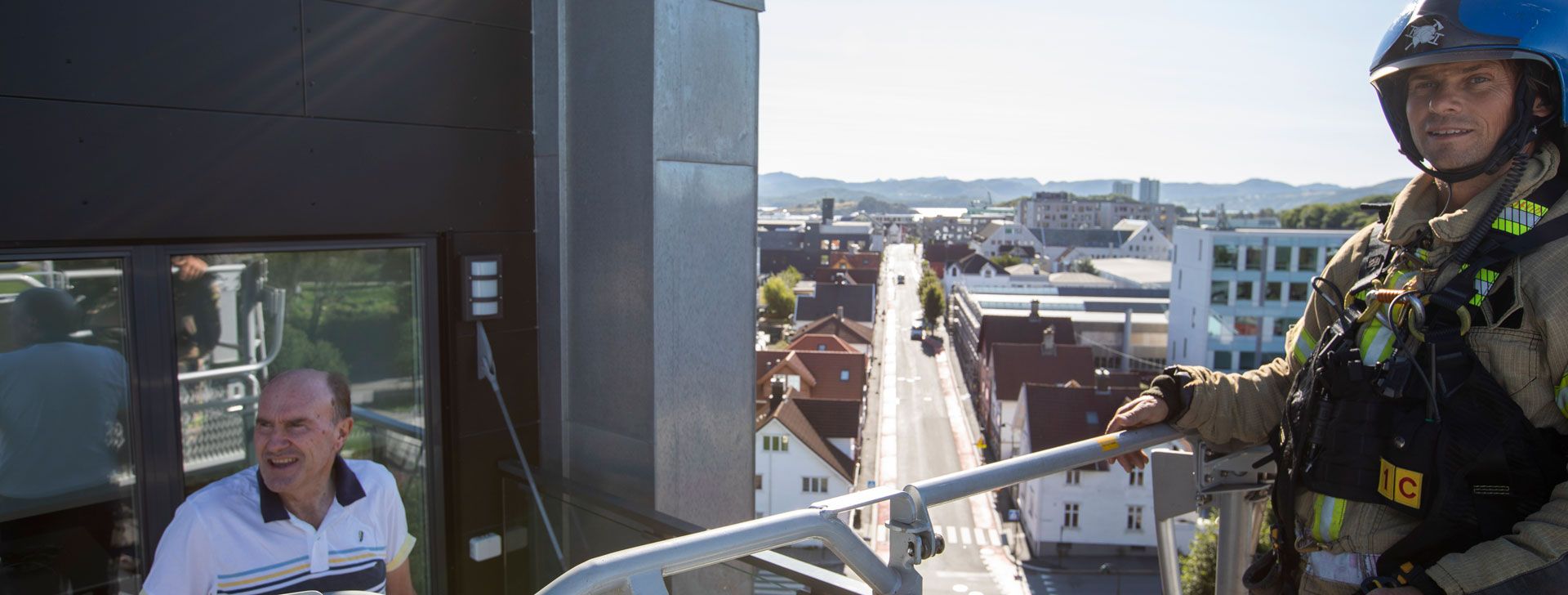 Brannkonstabel David Riska hilser på styreleder Magne Lea i høyden