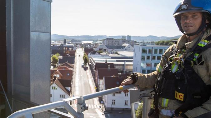 Brannkonstabel David Riska hilser på styreleder Magne Lea i høyden