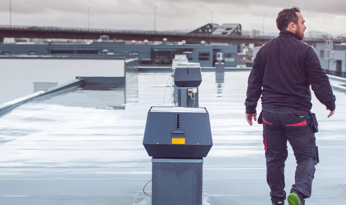 Vaktmester sjekker ventilasjon på taket