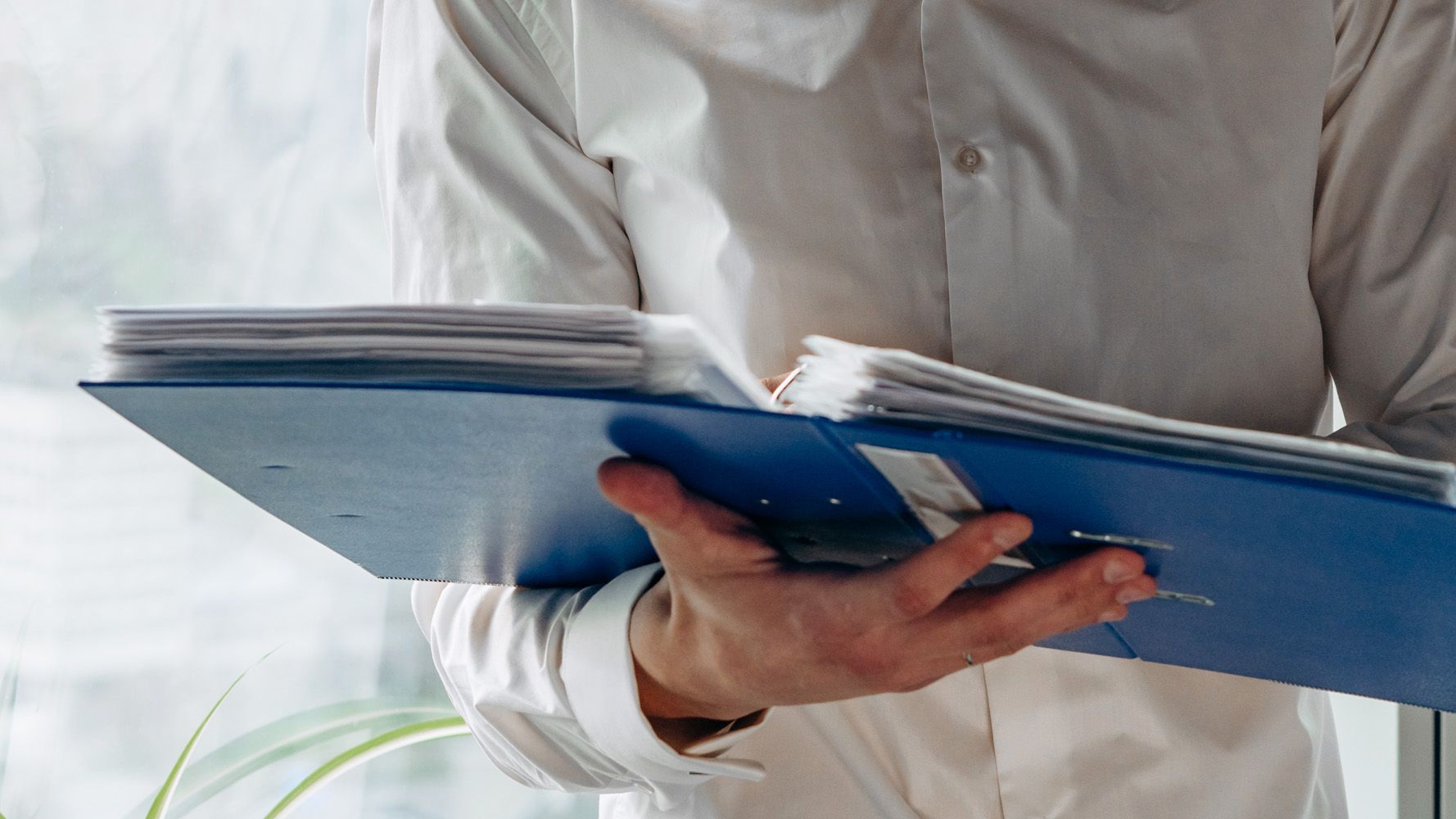 mann som holder en blå perm