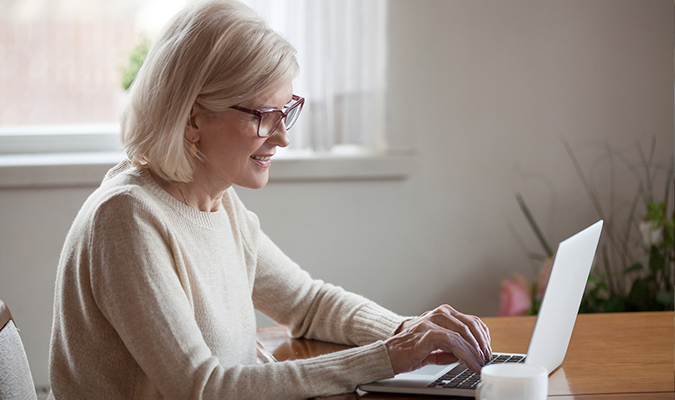 Dame sitter foran en pc