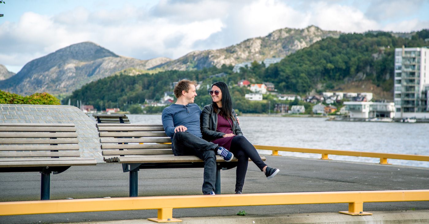 Par sitter på benk ved kaikant