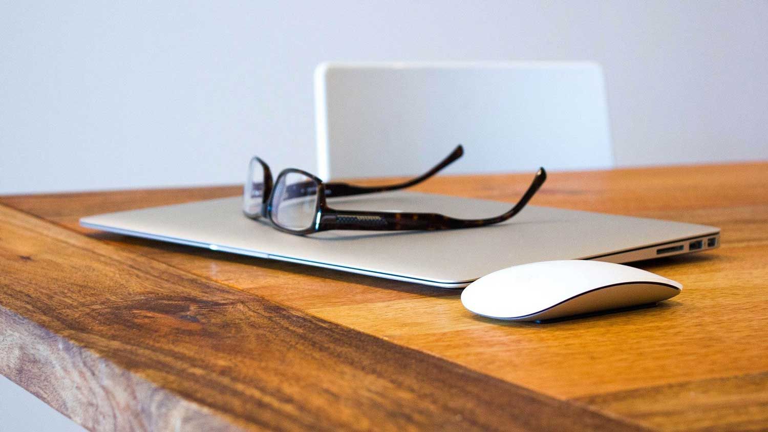 briller ligger på en bærbar pc