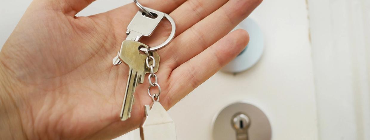 husnøkler i hånd ved inngangsdør